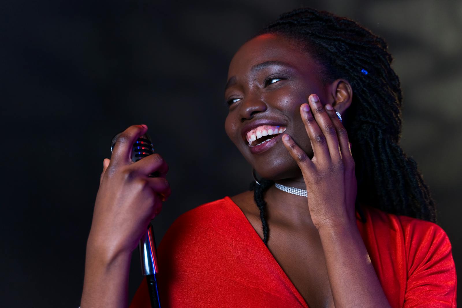 Portrait of a smiling singer holding a microphone, expressing joy and happiness.