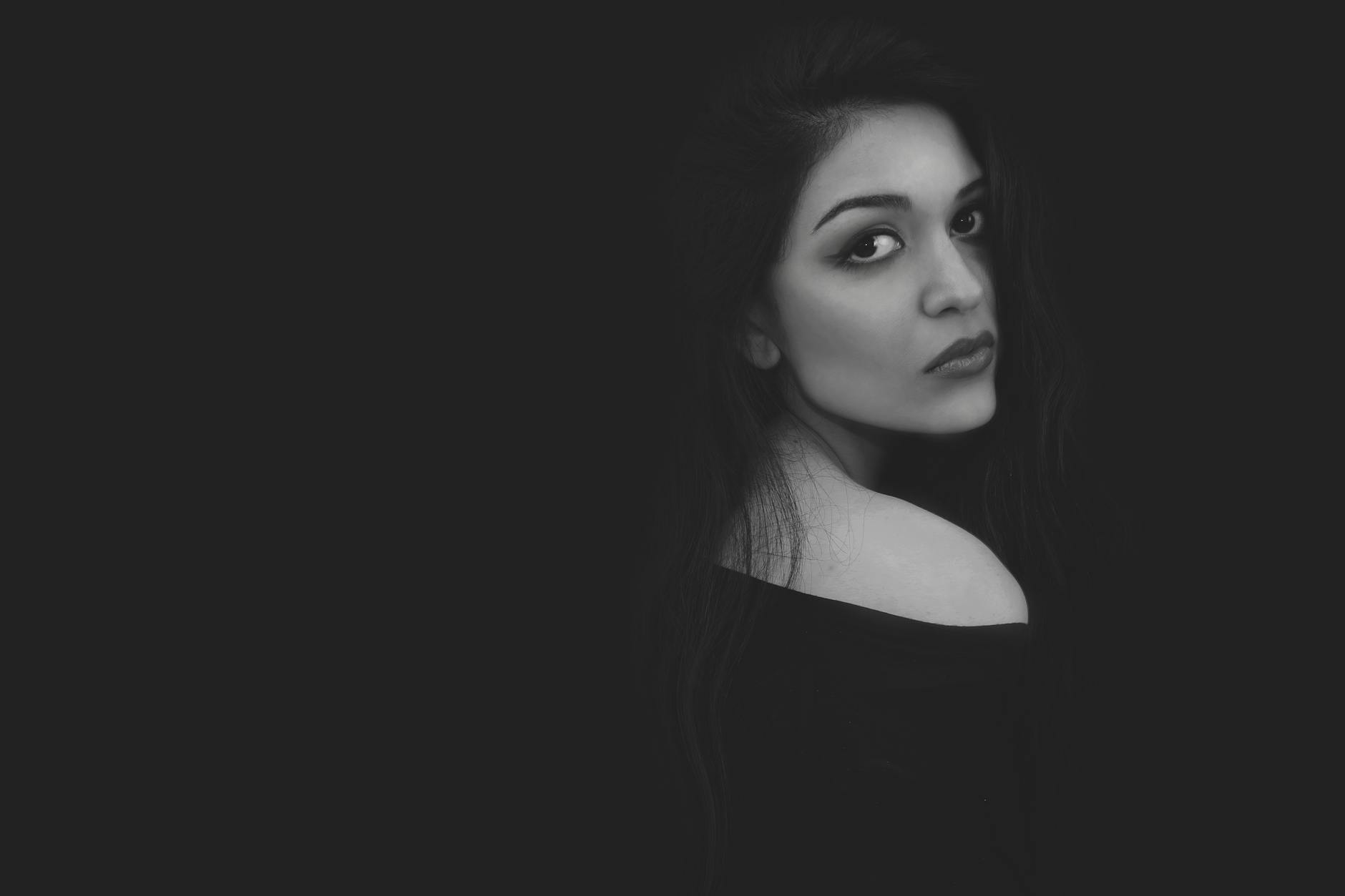 A captivating black and white portrait highlighting the elegance and beauty of a woman with a myster