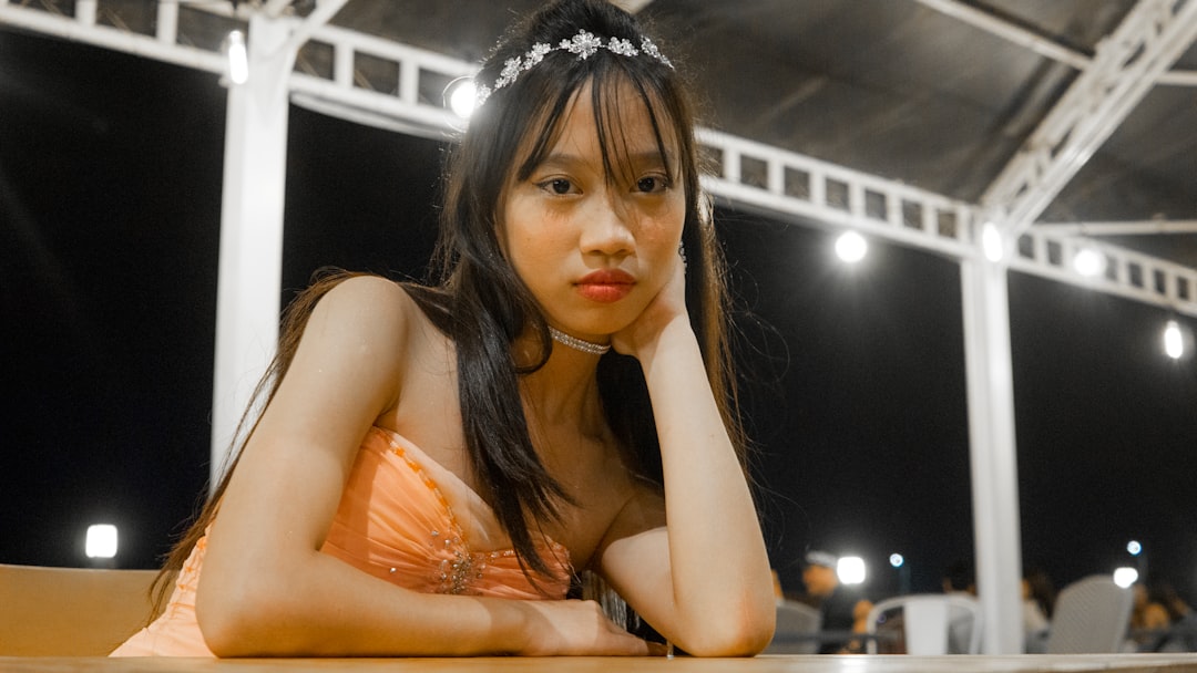 a woman sitting at a table with her hand on her chin