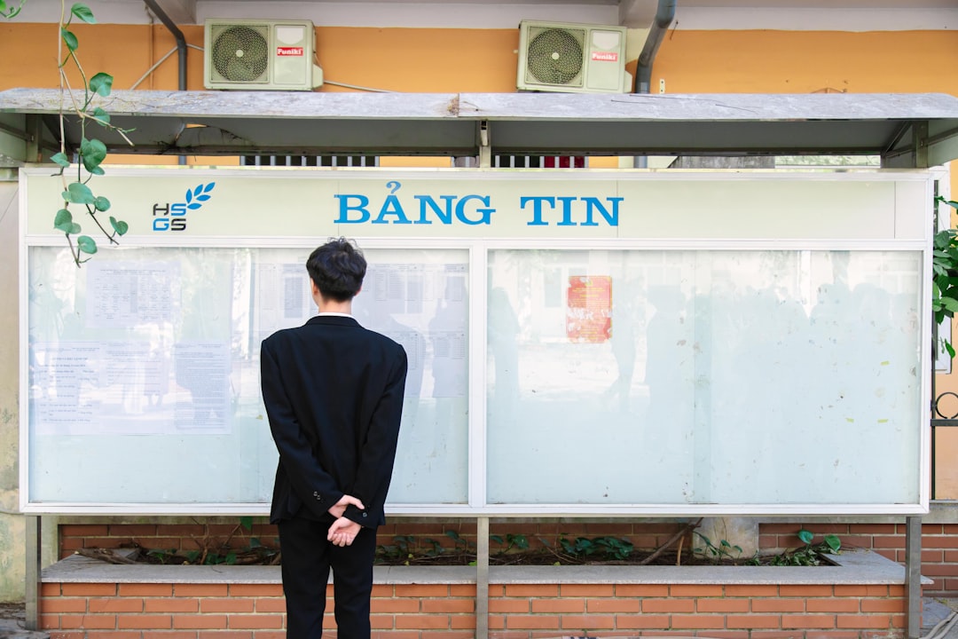 A man in a suit standing in front of a sign