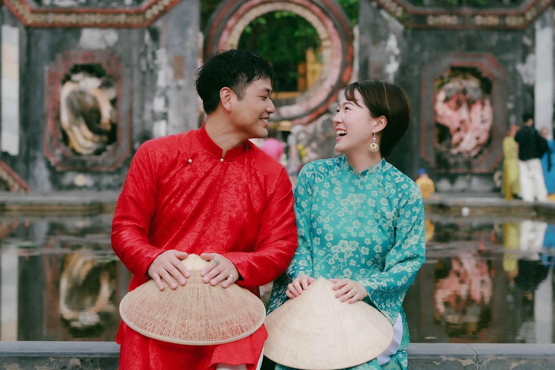 Couple in traditional clothing holding conical hats