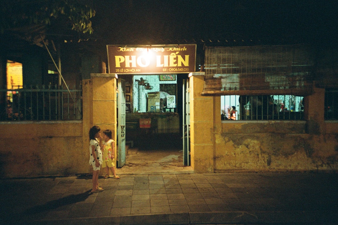 a couple of girls stand outside a small store