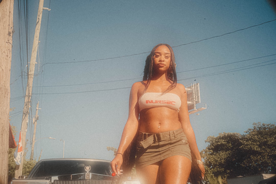 a woman in a bikini standing next to a car